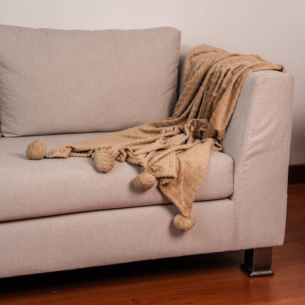 COBIJA ESSENTIALS CANALES POMPOM ALMENDRA SIESTA